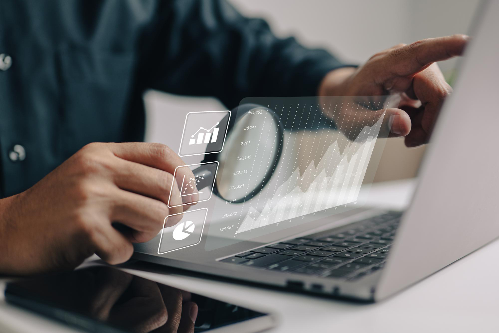 A person reviewing charts and analytics on a laptop screen while pointing at the data
